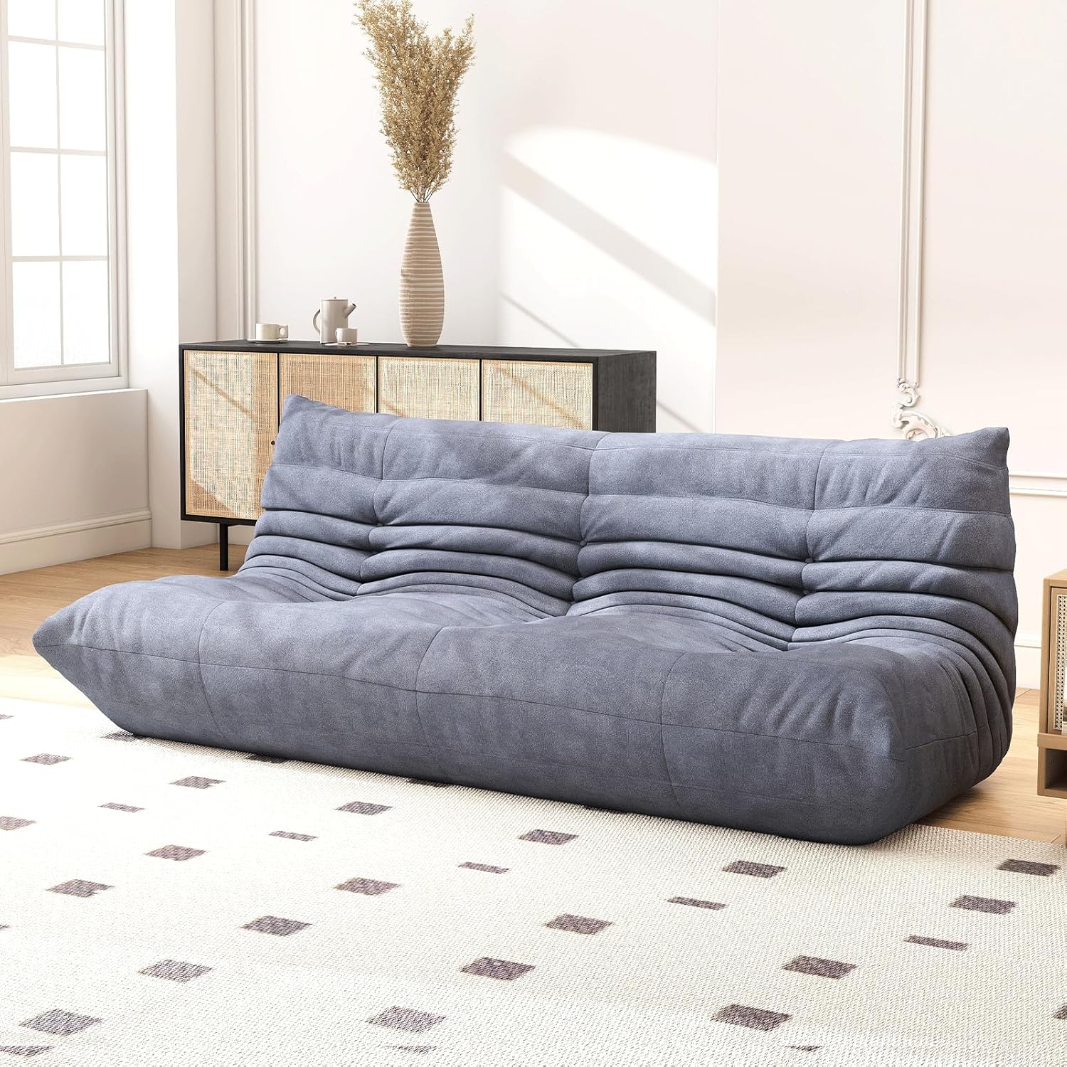 Low gray armless floor sofa in a minimal apartment