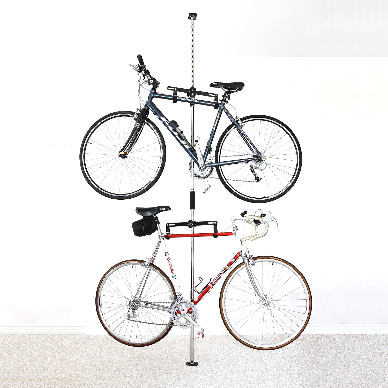 Two bikes arranged one above the other on a freestanding rack in a compact utility corner